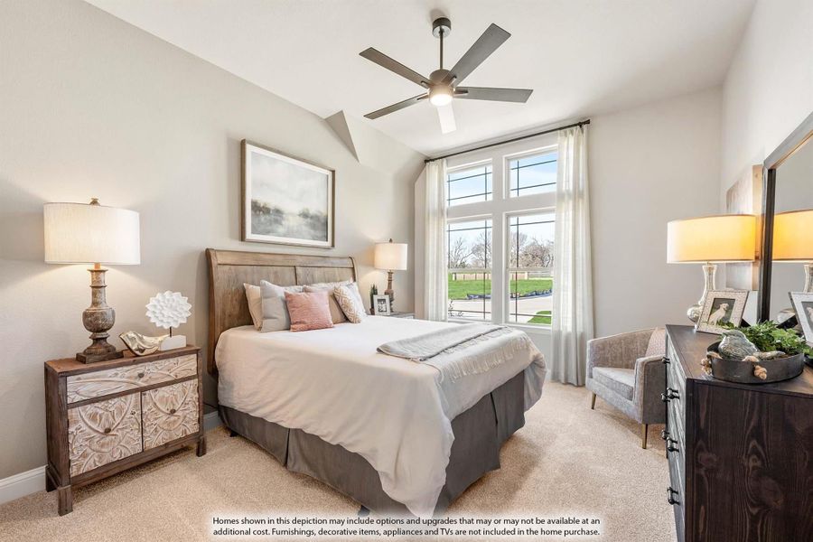 Bedroom with vaulted ceiling, ceiling fan, large windows, and neutral carpet flooring Bedroom with vaulted ceiling, ceiling fan, large windows, and neutral carpet flooring