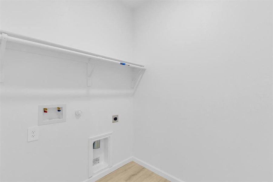 Laundry area with hookup for a gas dryer, light wood finished floors, hookup for a washing machine, and electric dryer hookup