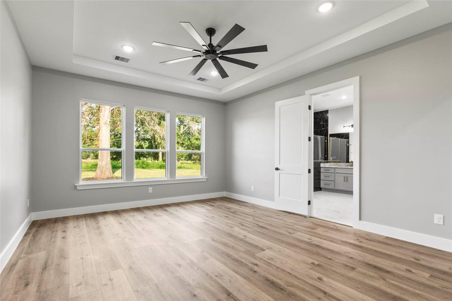 The large primary bedroom with en-suite bath and a peaceful view of the large back yard with mature trees. The large primary bedroom with en-suite bath and a peaceful view of the large back yard with mature trees.