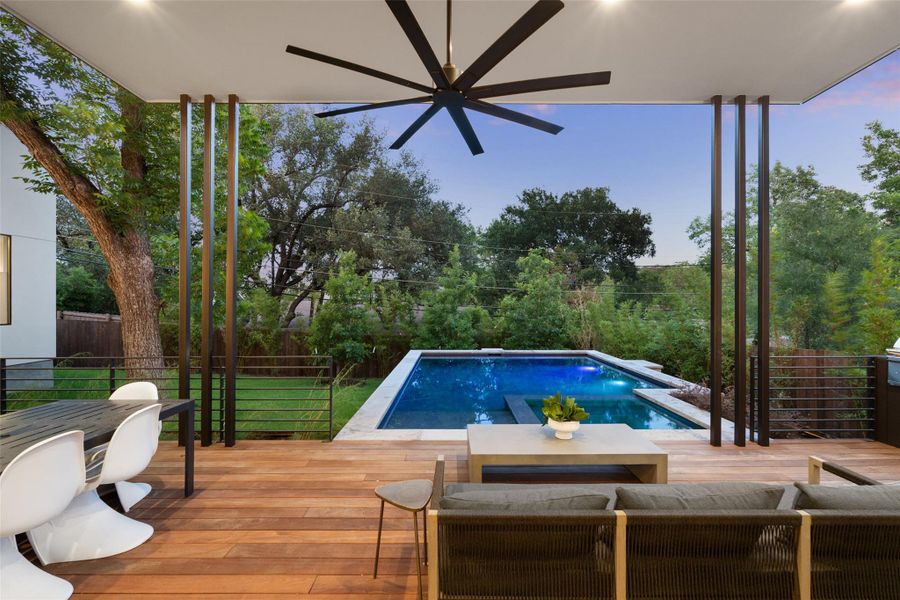 View of swimming pool featuring a deck, a fenced backyard, and a ceiling fan View of swimming pool featuring a deck, a fenced backyard, and a ceiling fan