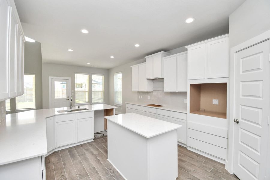 Culinary haven, featuring granite countertops, a tile backsplash, stainless steel appliances (to be installed), and 42” upper cabinets. Culinary haven, featuring granite countertops, a tile backsplash, stainless steel appliances (to be installed), and 42” upper cabinets.