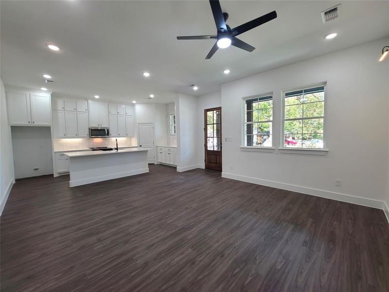 Kitchen with sink, dark hardwood / wood-style flooring, white cabinetry, ceiling fan, and a kitchen island with sink