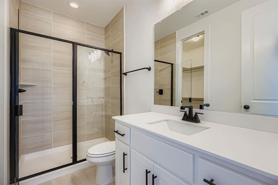 Bathroom featuring a stall shower, vanity, light tile patterned flooring, and recessed lighting Bathroom featuring a stall shower, vanity, light tile patterned flooring, and recessed lighting