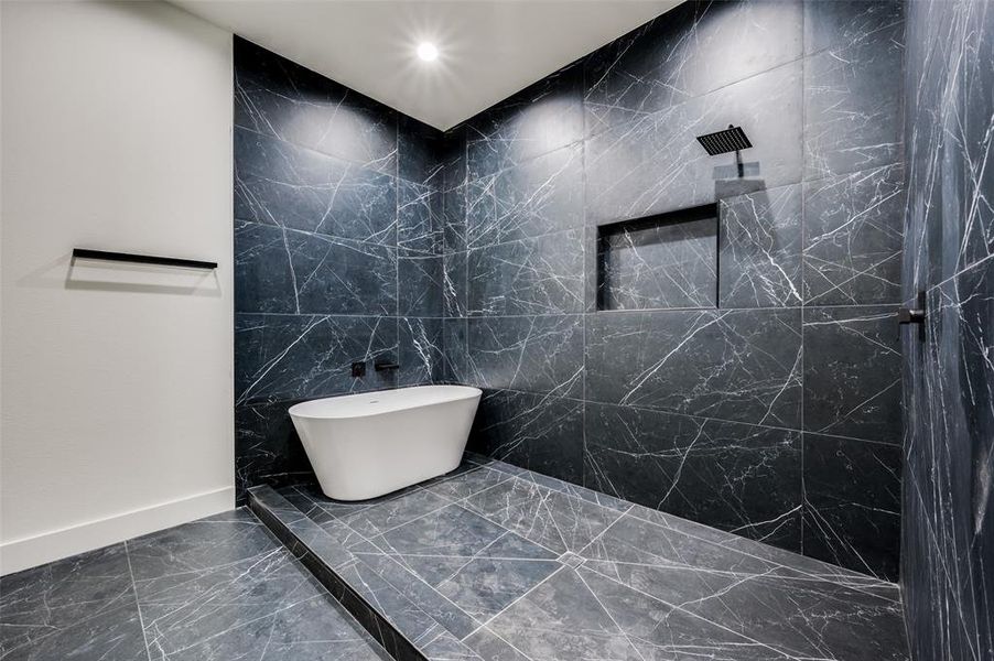 Bathroom featuring plus walk in shower and tile walls