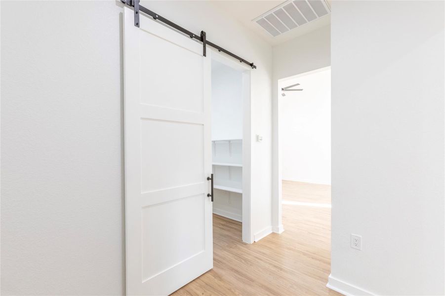 Spacious pantry with a stylish sliding barn door.