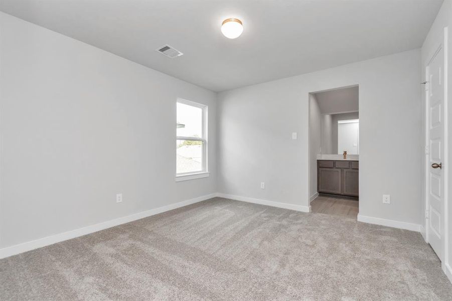 Secondary bedroom features plush carpet, custom paint, large window with privacy blinds and access to the Jack and Jill bath. Sample photo of completed home with similar floor plan. As-built interior colors and selections may vary.