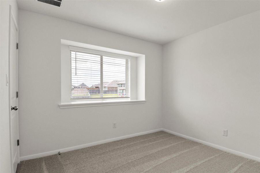 Empty room with carpet flooring and baseboards Empty room with carpet flooring and baseboards