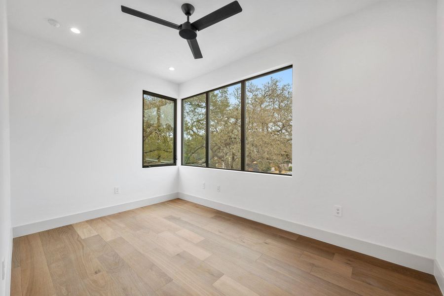 Spare room with light wood-style flooring, ceiling fan, healthy amount of natural light, and recessed lighting