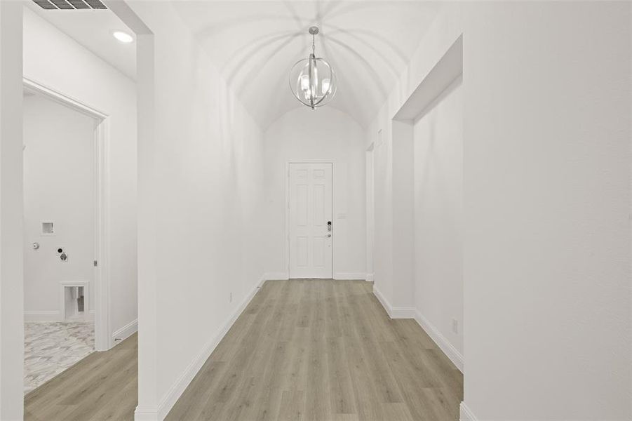 Hallway with light wood-style floors, a chandelier, and recessed lighting Hallway with light wood-style floors, a chandelier, and recessed lighting