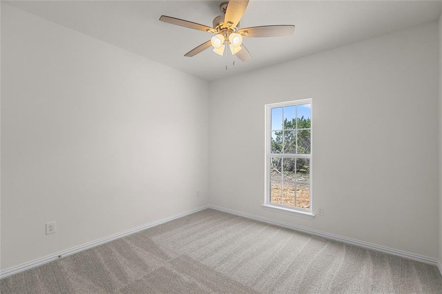 Carpeted empty room with baseboards and ceiling fan