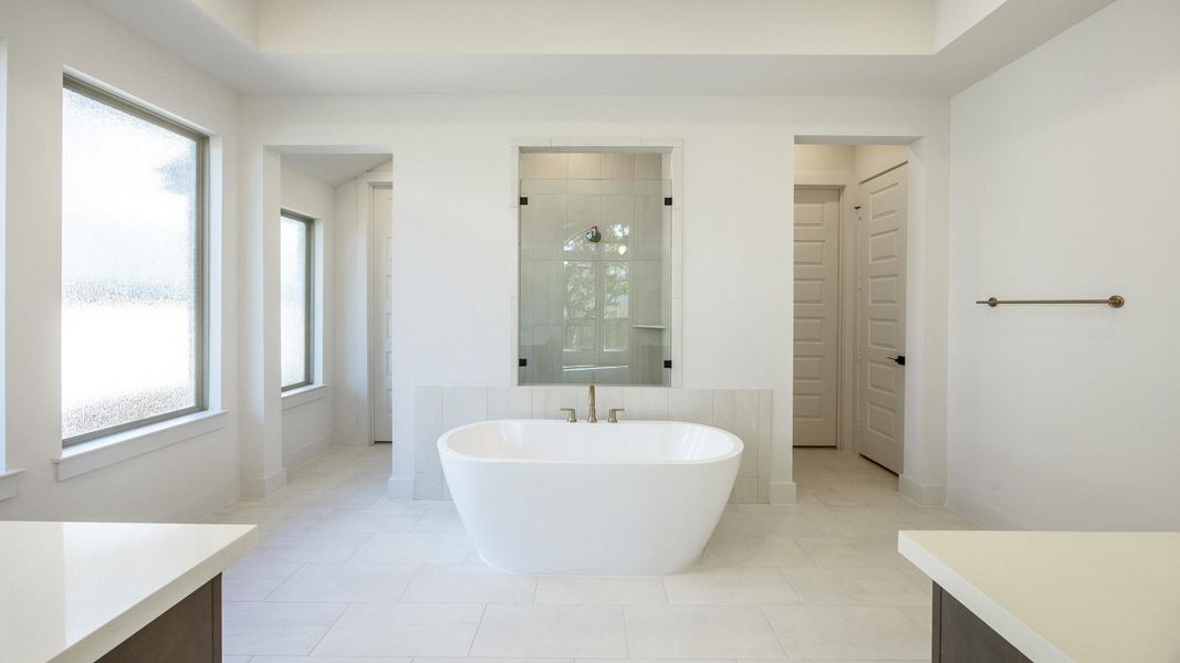 Bathroom with a shower stall, vanity, a soaking tub, and light tile patterned floors