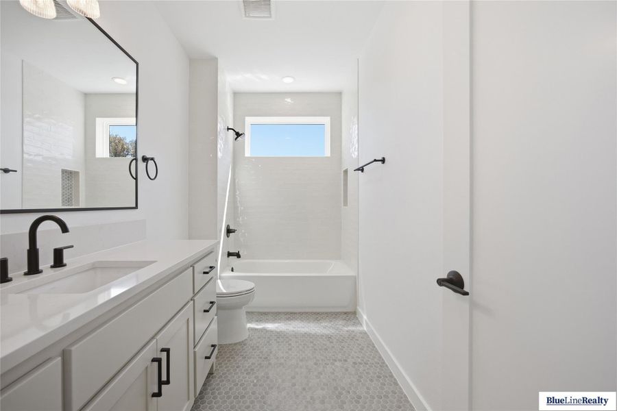 Full bath featuring vanity, tub / shower combination, and light tile patterned floors