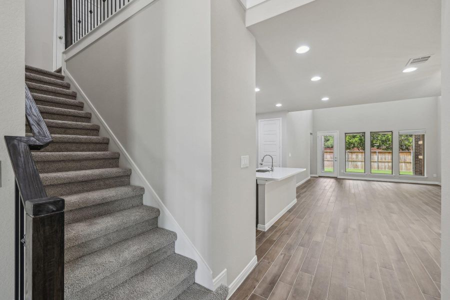 Staircase with wood finished floors, recessed lighting, and baseboards Staircase with wood finished floors, recessed lighting, and baseboards