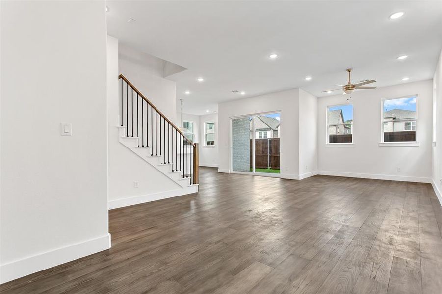 Unfurnished living room featuring ceiling fan and dark hardwood / wood-style floors