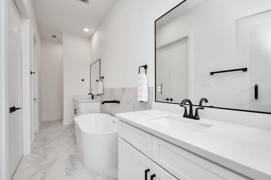 Another view of the luxury that is the primary bath, highlighted the two beautifully appointed vanity areas, spacious soaking tub and walk in closet