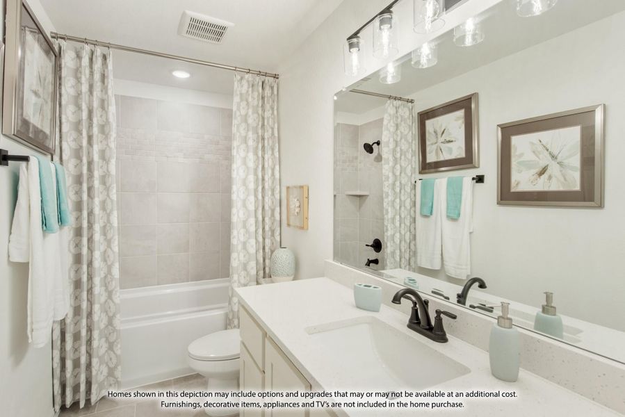 Bathroom with white vanity, large mirror, tub-shower combo with patterned curtain, and pendant lights overhead.