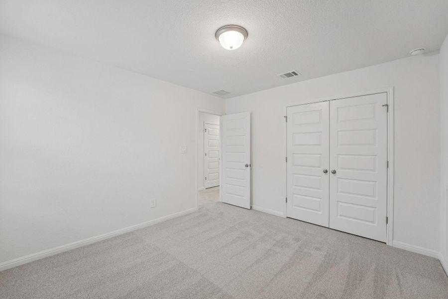 Unfurnished bedroom with light colored carpet and a closet