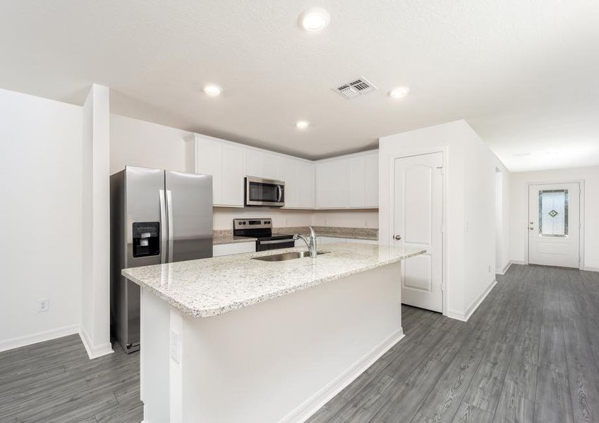 A foyer leads to a kitchen with white granite countertops