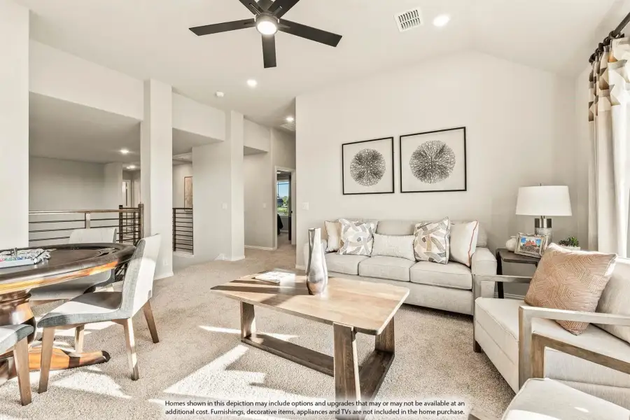Open living room with carpet, ceiling fan, neutral sofa, wood coffee table, and dining area with staircase visible.