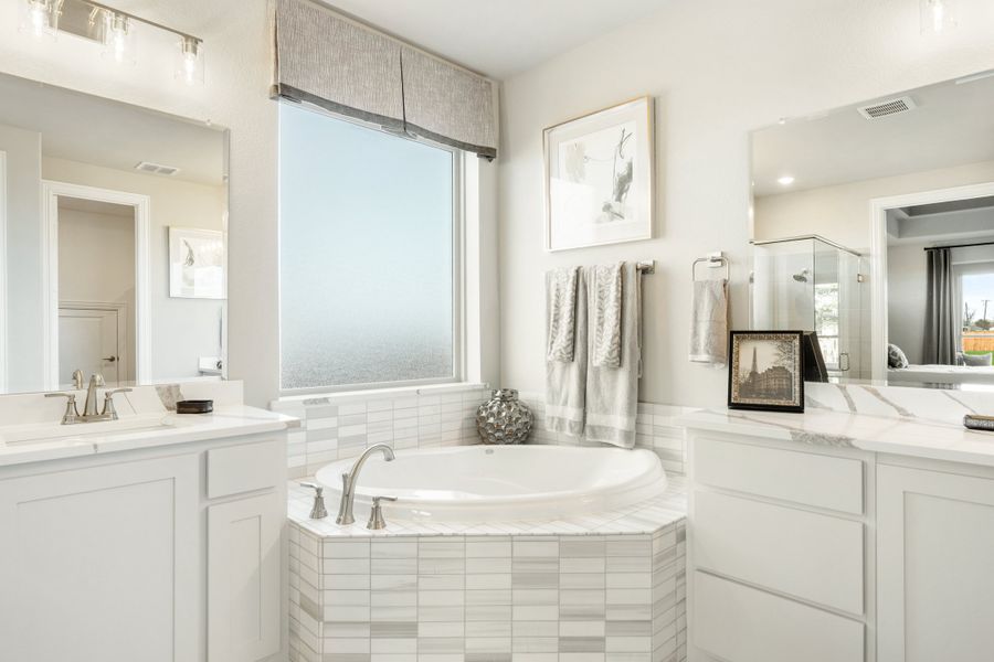 Master bathroom with corner soaking tub, tile surround, dual vanities, and a separate glass shower. Master bathroom with corner soaking tub, tile surround, dual vanities, and a separate glass shower.