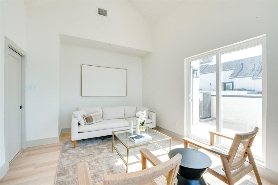 Living room featuring light hardwood / wood-style flooring and high vaulted ceiling