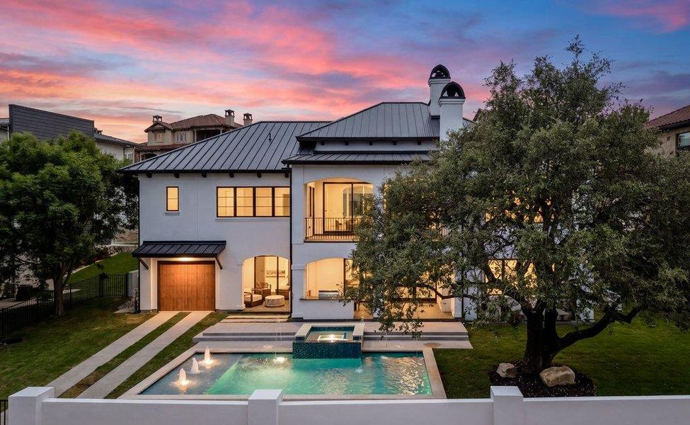 White stucco exterior with a dark metal roof and arched entryways