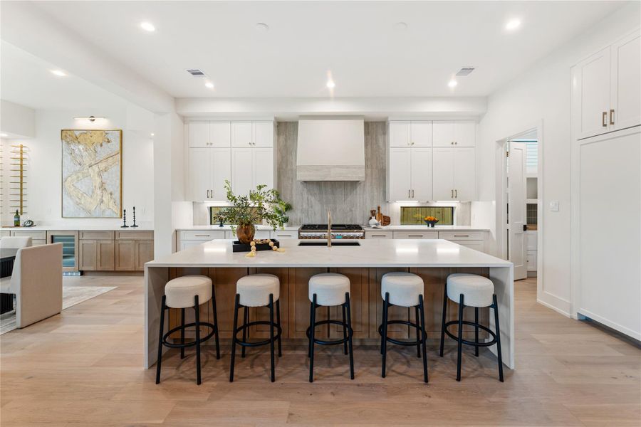 Spectacular oversized island measuring 10' x 5' transforms the kitchen into an entertainer's paradise, with generous seating for five guests. The elegant waterfall design creates a sophisticated focal point while providing abundant workspace.