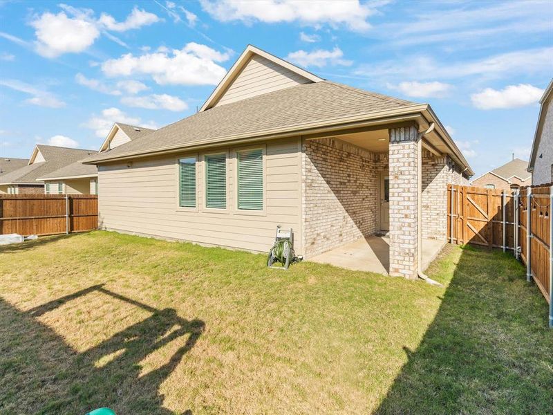 Back of property with a lawn and a patio