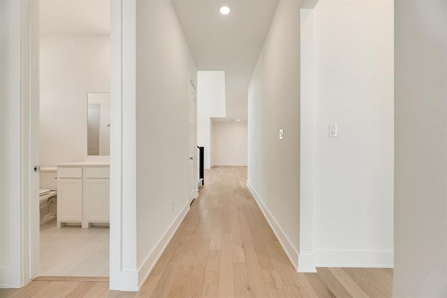 Hallway with light wood-type flooring and recessed lighting Hallway with light wood-type flooring and recessed lighting