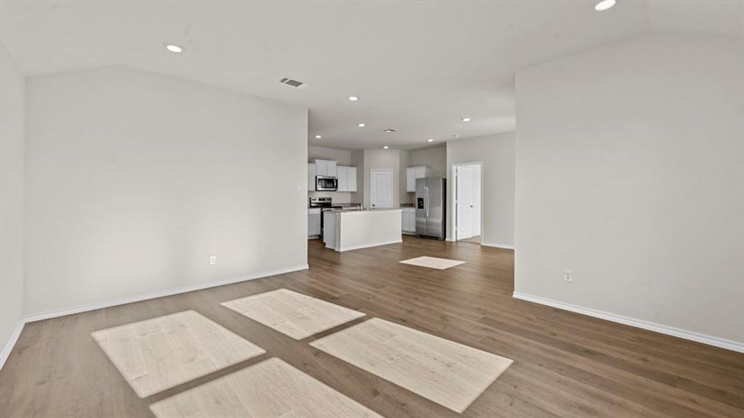 Unfurnished living room featuring recessed lighting, dark wood finished floors, and vaulted ceiling