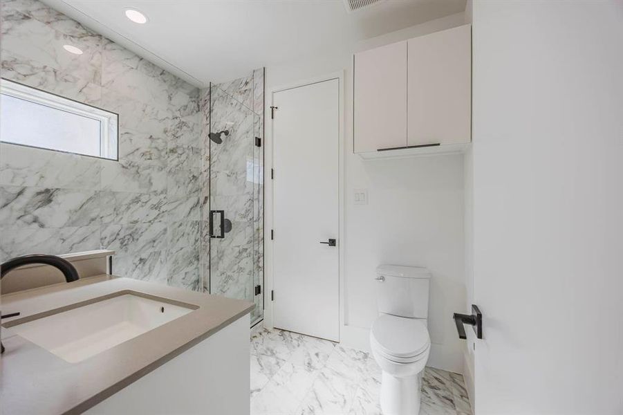 Full bathroom with vanity, a marble finish shower, light marble finish floors, recessed lighting, and tile walls Full bathroom with vanity, a marble finish shower, light marble finish floors, recessed lighting, and tile walls