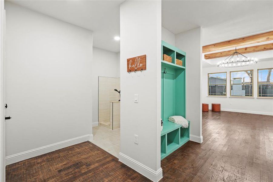 Hall featuring dark wood-style flooring and hanging lights