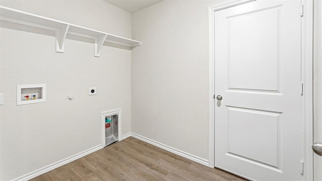 Laundry room featuring hookup for a gas dryer, light wood finished floors, hookup for a washing machine, and electric dryer hookup Laundry room featuring hookup for a gas dryer, light wood finished floors, hookup for a washing machine, and electric dryer hookup