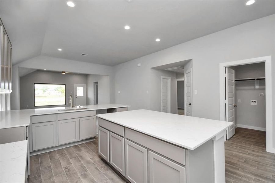 This generously spacious layout boasts a massive granite island, high ceilings, soft-close cabinets, granite countertops, stainless steel appliances (to be installed), a sleek tile backsplash, and recessed lighting. Sample photo of completed home. As-built color and selections may vary.