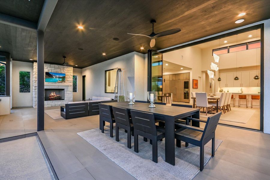 View of patio / terrace with an outdoor stone fireplace, an outdoor living / dining area, and ceiling fan View of patio / terrace with an outdoor stone fireplace, an outdoor living / dining area, and ceiling fan