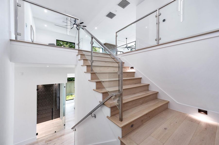 Oversized staircase featuring integrated LED lighting,  wide 8-inch floorboards and 5½-inch wide wood stair treads, combining modern illumination with elegant, spacious flooring.