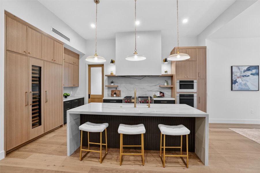 A contemporary kitchen offers sleek integrated appliances and warm wooden cabinetry.
