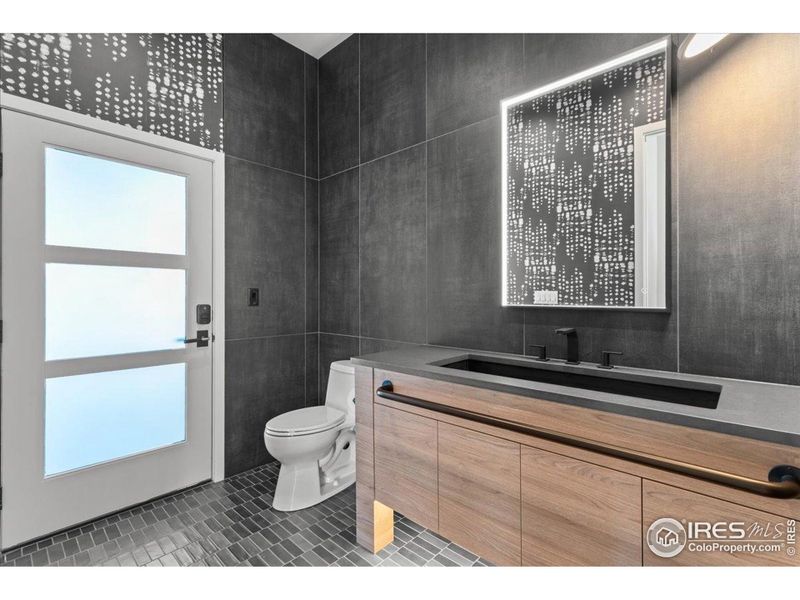 Main level half bath w/ door to exterior to patio (outdoor kitchen and sink area)