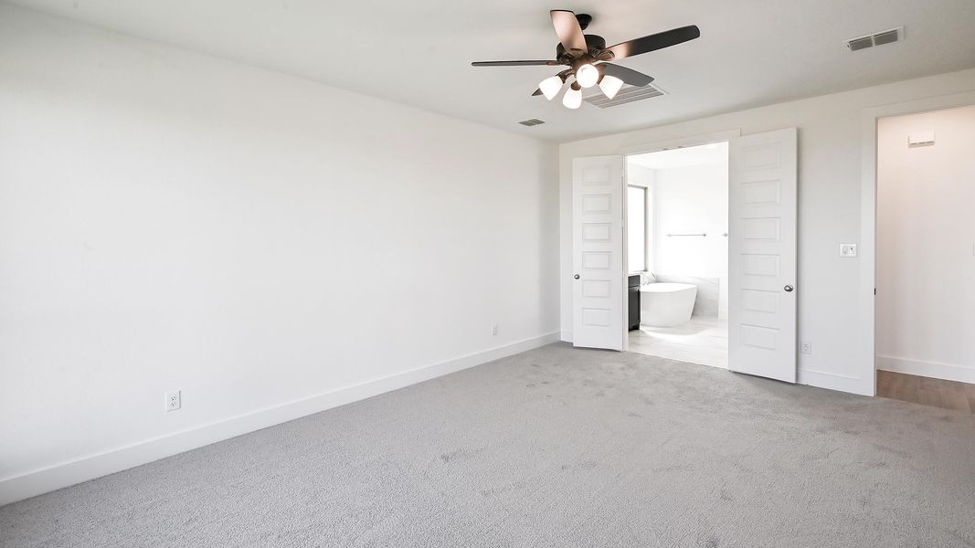 Unfurnished bedroom with carpet flooring, ensuite bath, and a ceiling fan