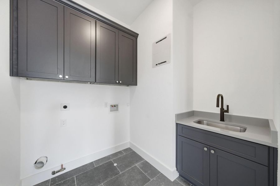 The utility room conveniently includes a sink and cabinetry. The utility room conveniently includes a sink and cabinetry.