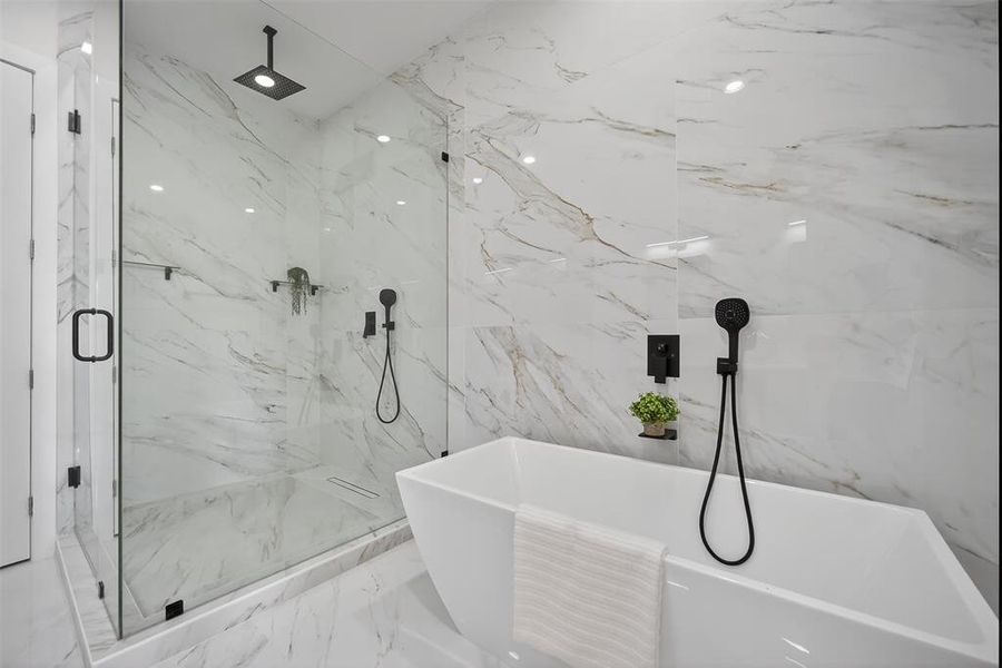 Full bath featuring a marble finish shower, a freestanding bath, marble tiled flooring, and stone wall