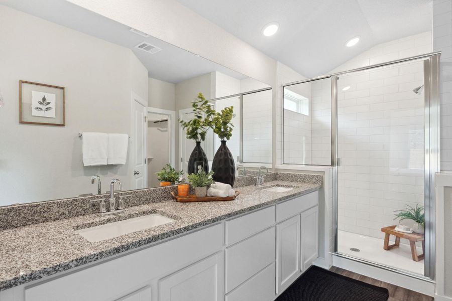 Bathroom featuring a walk-in large shower, double vanity, lofted ceiling, recessed lighting, and wood-style flooring Bathroom featuring a walk-in large shower, double vanity, lofted ceiling, recessed lighting, and wood-style flooring