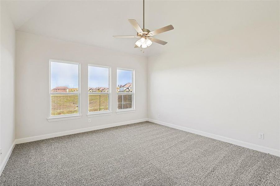 Spare room with carpet flooring, vaulted ceiling, and ceiling fan