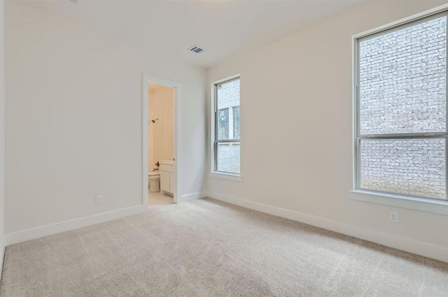 Spare room featuring a wealth of natural light and light colored carpet