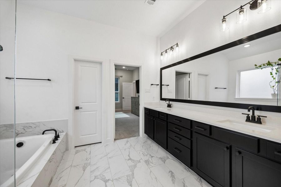 Relax and unwind in the luxurious soaking tub perfectly positioned beside the oversized glass-enclosed shower, creating a serene spa-inspired atmosphere. Relax and unwind in the luxurious soaking tub perfectly positioned beside the oversized glass-enclosed shower, creating a serene spa-inspired atmosphere.