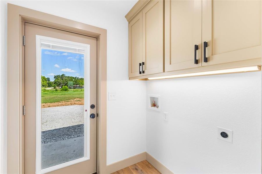 Laundry room featuring light wood-style floors, washer hookup, cabinet space, and hookup for an electric dryer