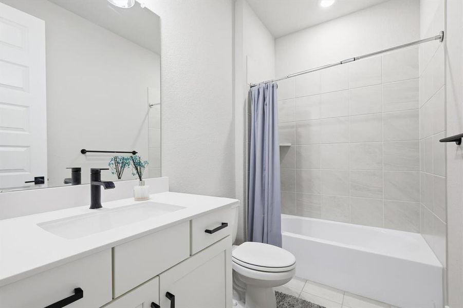 Bathroom with shower / bath combo, vanity, and light tile patterned floors