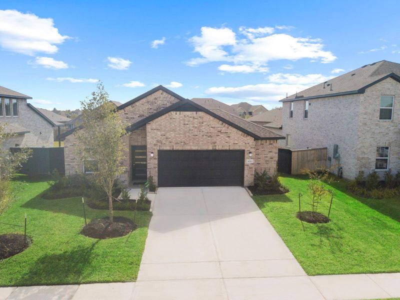 Beautiful curb appeal! The home’s front elevation highlights modern lines, a wide driveway, and carefully landscaped greenery that creates a welcoming first impression every time you arrive.