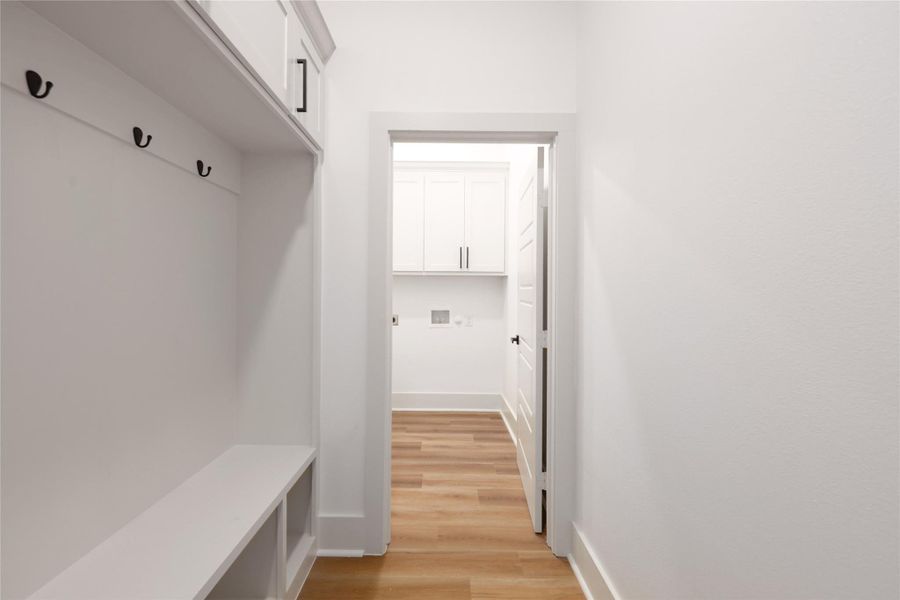 Mudroom with light wood-style floors and baseboards