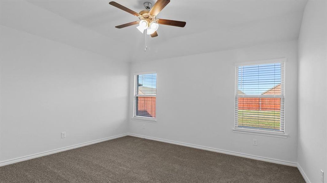 Unfurnished room with dark carpet and ceiling fan